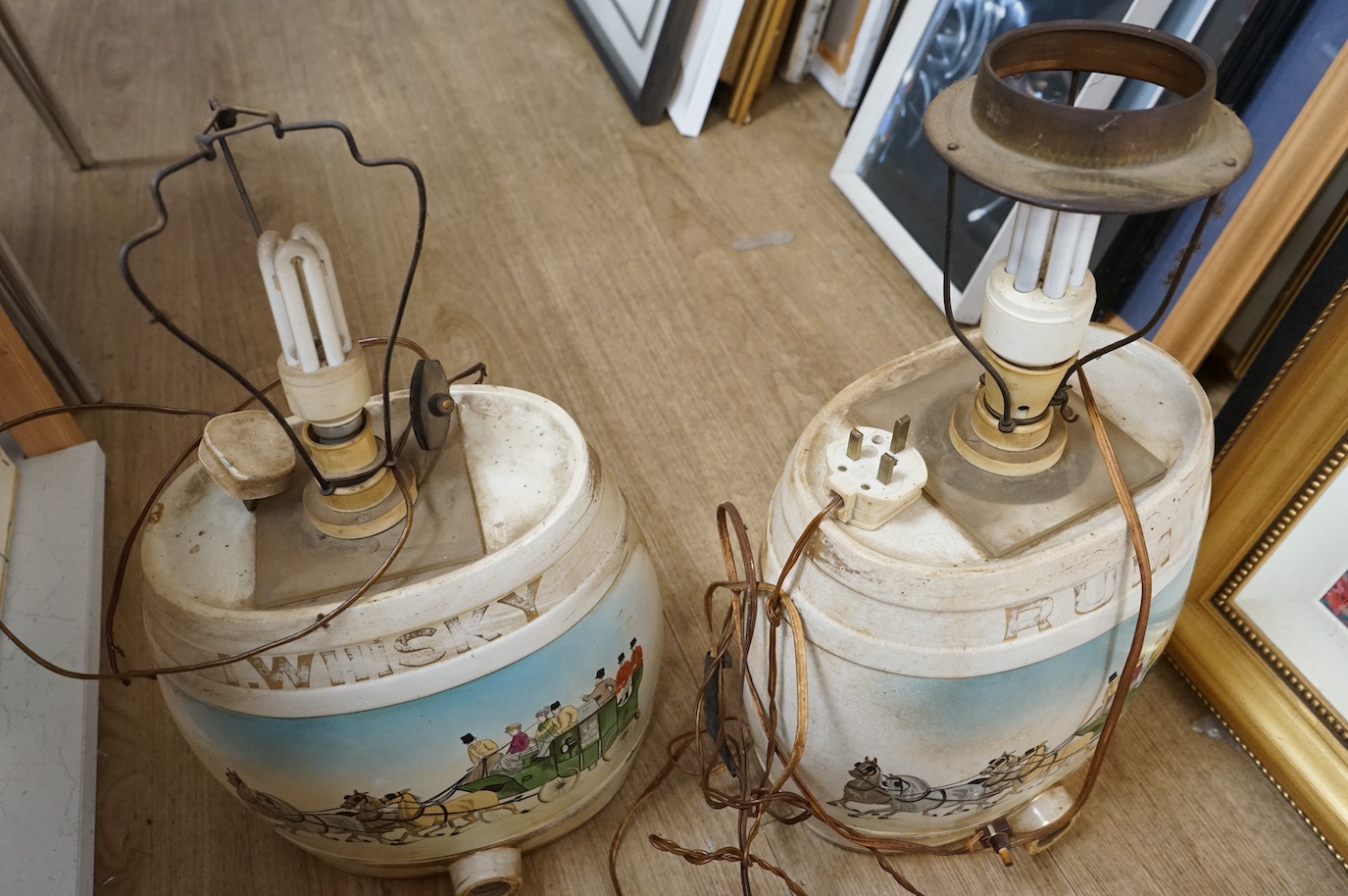 A pair of pottery Irish Whiskey and Rum spirit barrels, coaching scenes, converted to lamps, 56cm high overall